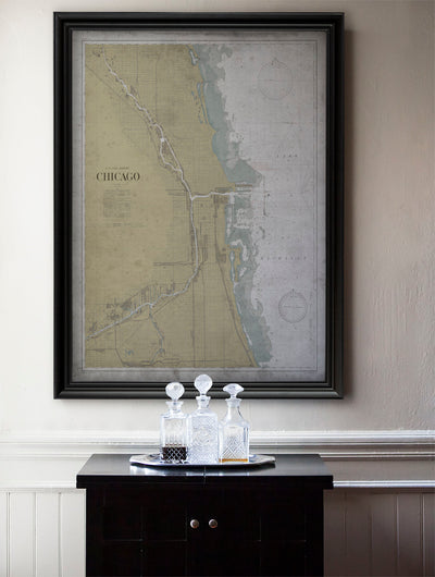 a framed map of Chicago, with a black tray holding three crystal goblets placed in front of it.