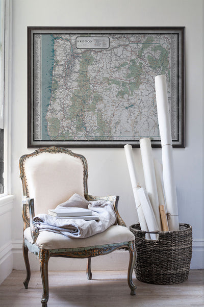Vintage historic map of Oregon in room with white walls with vintage furniture and vintage decor.