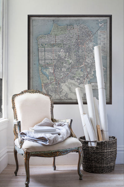 Vintage historic street map of San Francisco in room with white walls with vintage furniture and vintage decor.