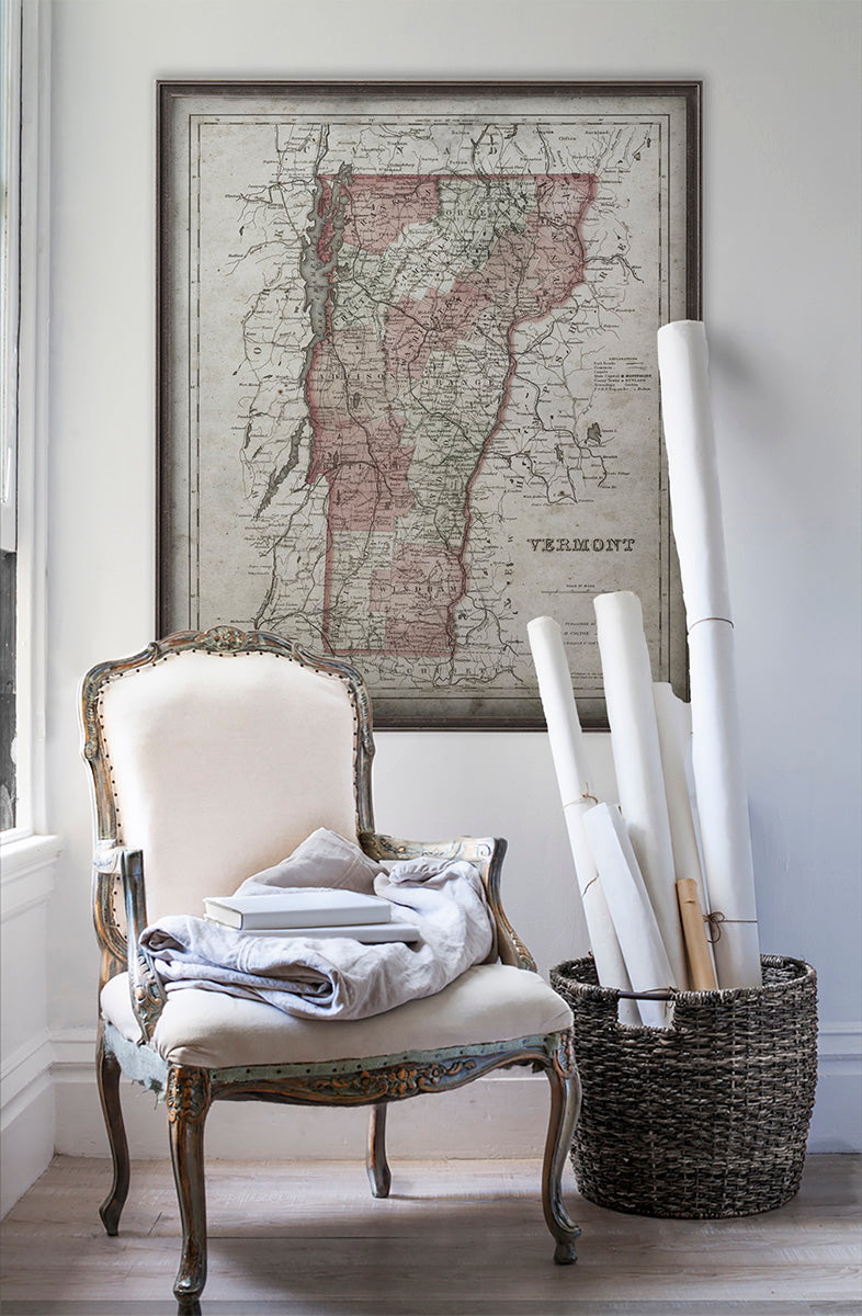 Vintage historic map of Vermont in room with white walls with vintage furniture and vintage decor.