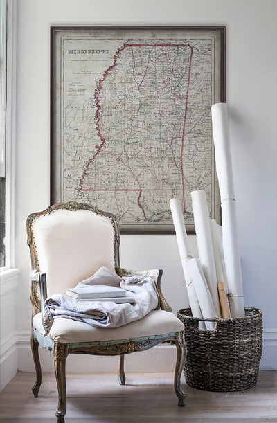 Vintage historic map of Mississippi in room with white walls with vintage furniture and vintage decor.