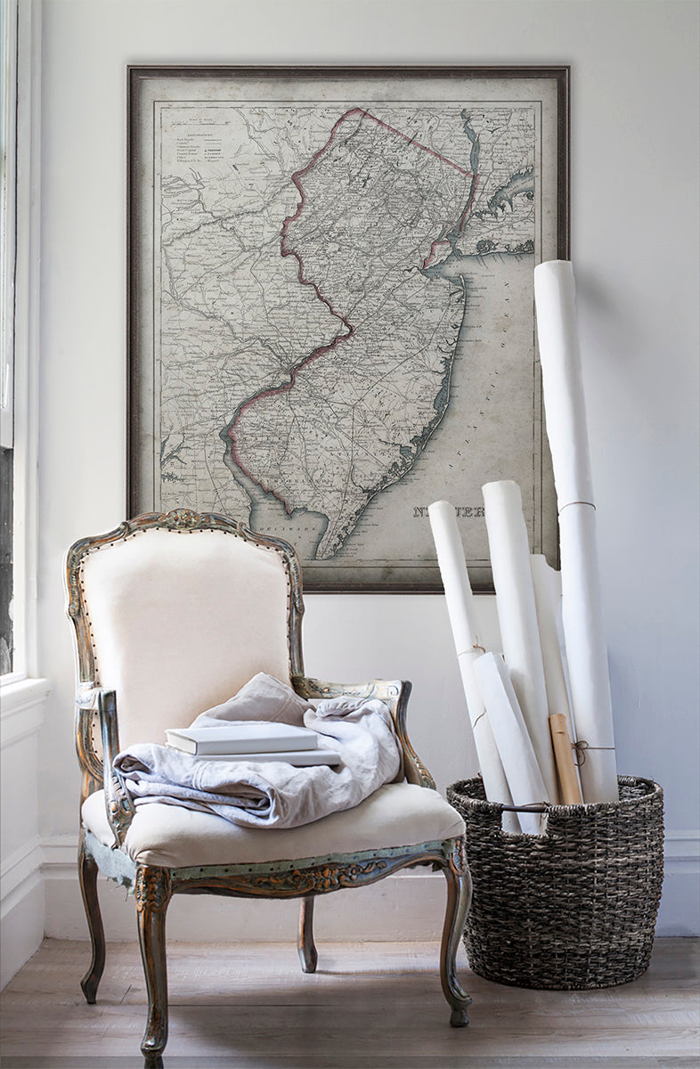 Vintage historic map of New Jersey in room with white walls with vintage furniture and vintage decor.