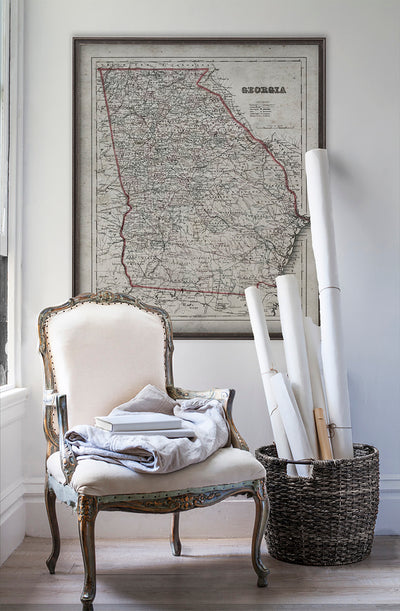 Vintage historic Georgia map in room with white walls with vintage furniture and vintage decor.