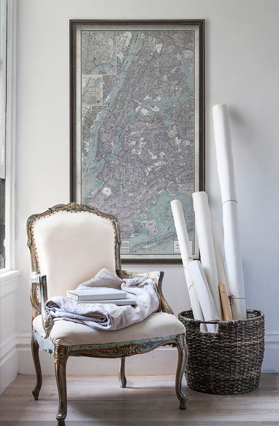 Vintage historic New York City map in room with white walls with vintage furniture and vintage decor.