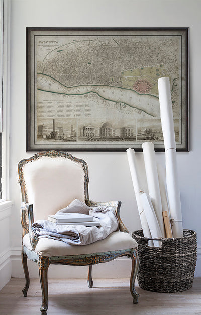 Vintage historic map of Calcutta in room with white walls with vintage furniture and vintage decor.