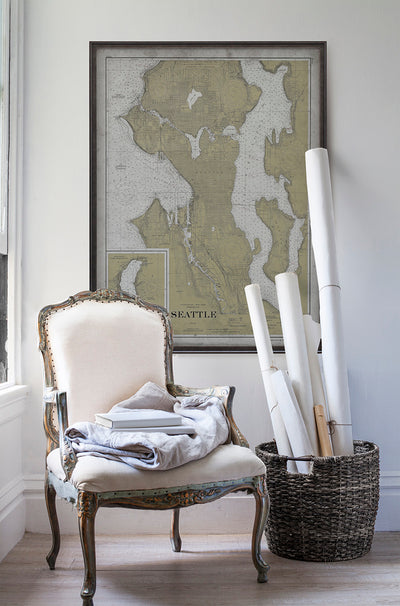 Vintage historic nautical chart of Seattle in room with white walls with vintage furniture and vintage decor.
