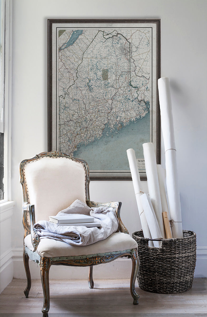 Vintage historic road map of Maine in room with white walls with vintage furniture and vintage decor.