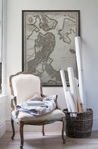 Vintage historic map of Boston in room with white walls with vintage furniture and vintage decor.