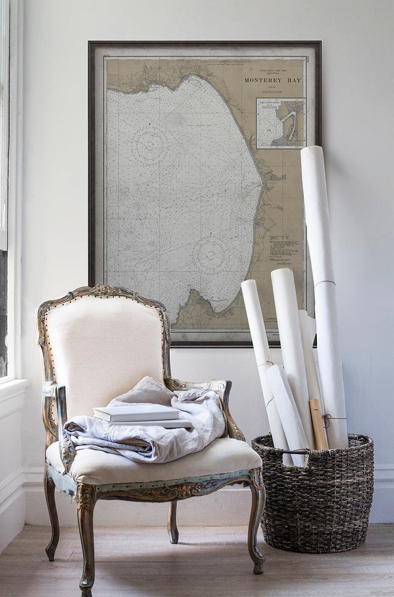 Vintage historic nautical chart of Monterey Bay in room with white walls with vintage furniture and vintage decor.