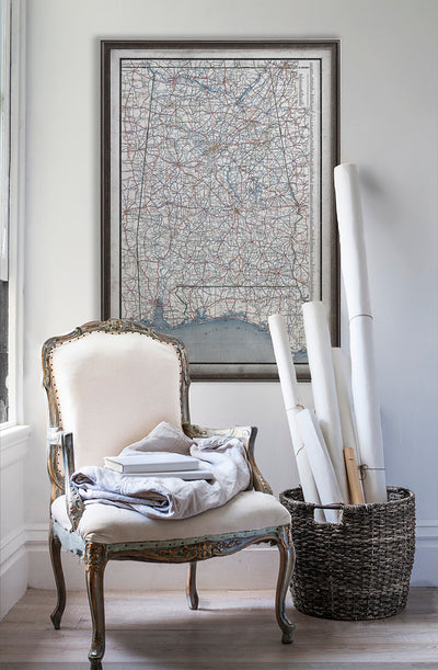 Vintage historic map of Alabama on white wall with vintage furniture and vintage decor.