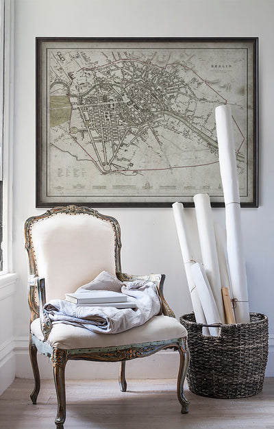 Vintage historic map of Berlin, Germany in room with white walls with vintage furniture and vintage decor.