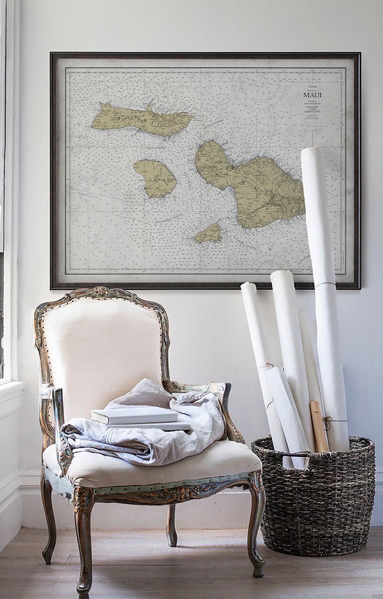 Vintage historic nautical chart of Maui in room with white walls with vintage furniture and vintage decor.