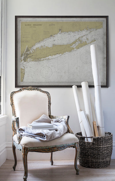 Vintage historic nautical chart of Long Island in room with white walls with vintage furniture and vintage decor.