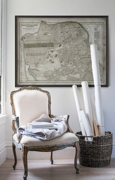 Vintage historic map of San Francisco in room with white walls with vintage furniture and vintage decor.