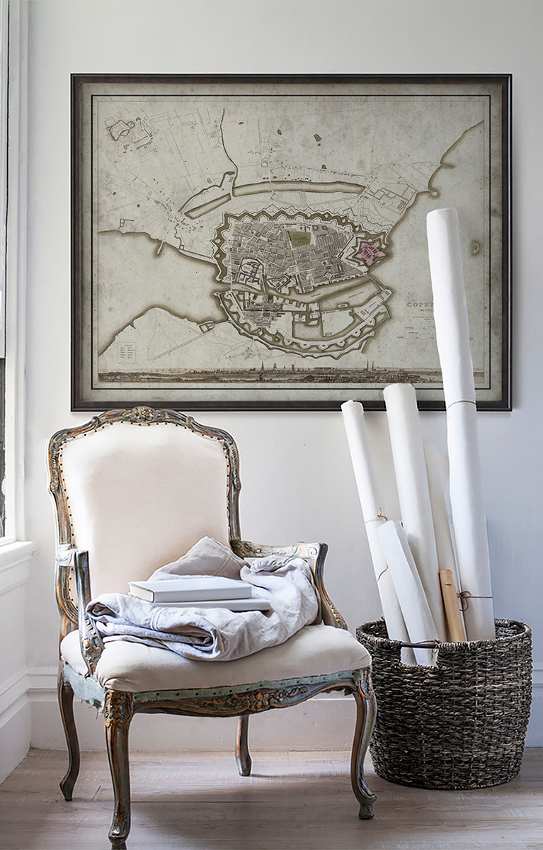 Vintage historic map of Copenhagen, Denmark in room with white walls with vintage furniture and vintage decor.