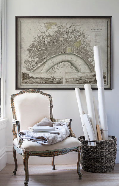 Vintage historic map of Bordeaux in room with white walls with vintage furniture and vintage decor.