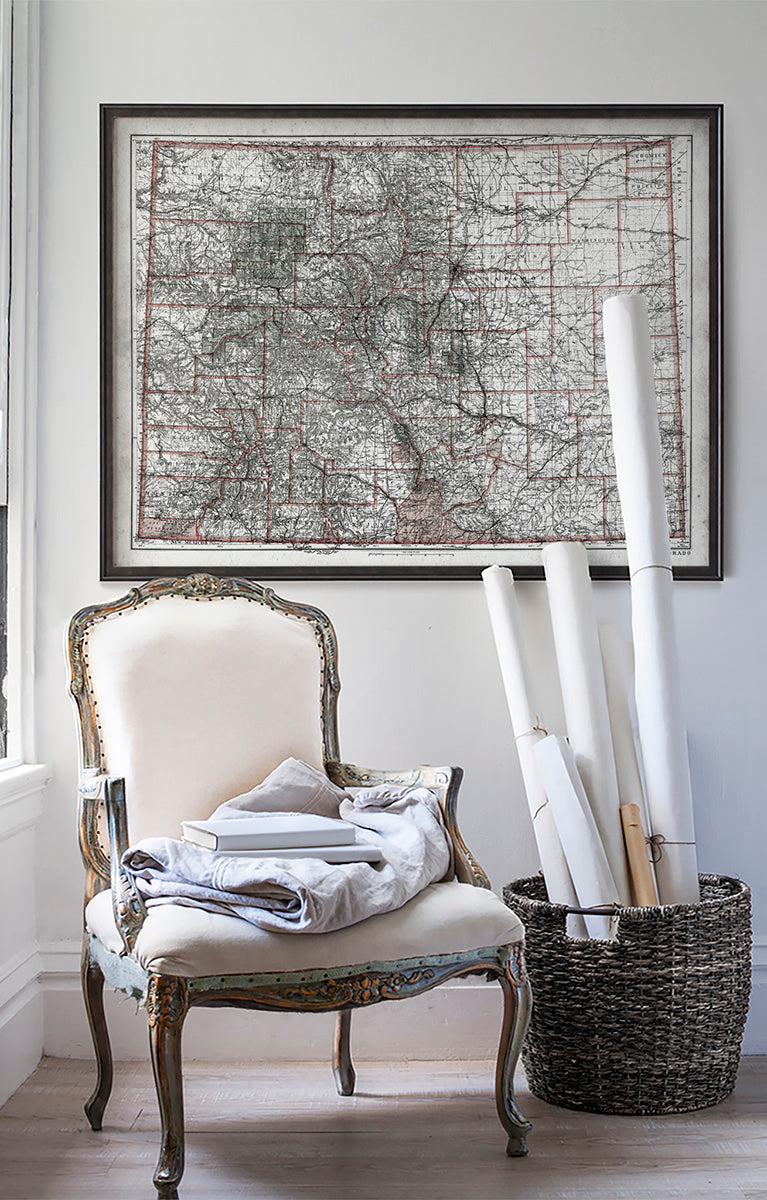 Vintage historic map of Colorado in room with white walls with vintage furniture and vintage decor.