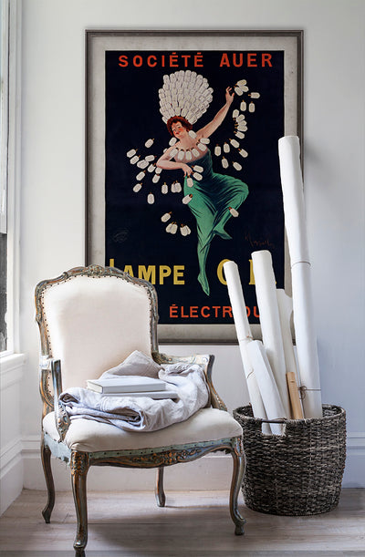 Électrique Lampe O.R. vintage poster wall art on white wall with vintage furniture and vintage decor.