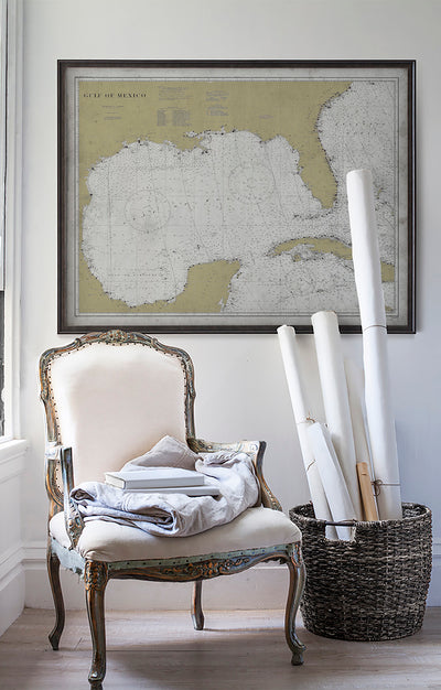 Vintage historic nautical chart of The Gulf of Mexico in room with white walls with vintage furniture and vintage decor.
