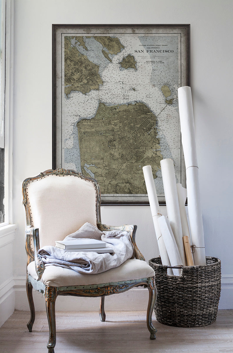 Vintage historic nautical chart of San Francisco in room with white walls with vintage furniture and vintage decor.