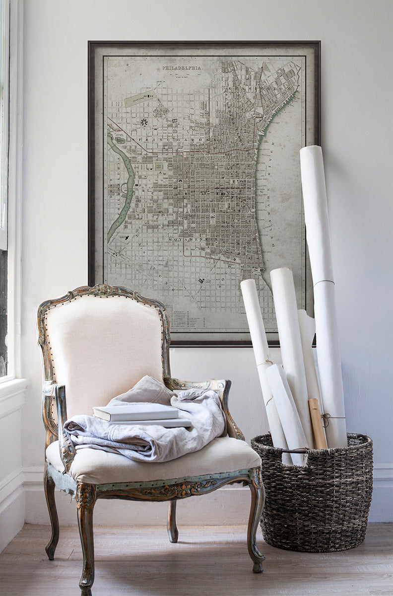 Vintage historic map of Philadelphia, Pennsylvania in room with white walls with vintage furniture and vintage decor.