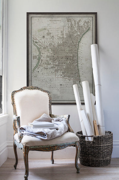 Vintage historic map of Philadelphia, Pennsylvania in room with white walls with vintage furniture and vintage decor.