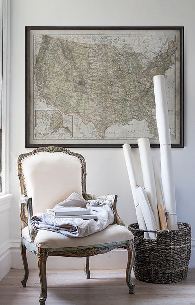 Vintage historic map of United States in room with white walls with vintage furniture and vintage decor.