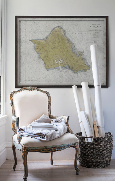 Vintage historic nautical chart of Oahu, Hawaii in room with white walls with vintage furniture and vintage decor.