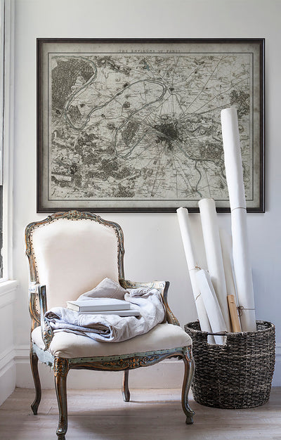 Vintage historic map of Paris in room with white walls with vintage furniture and vintage decor.
