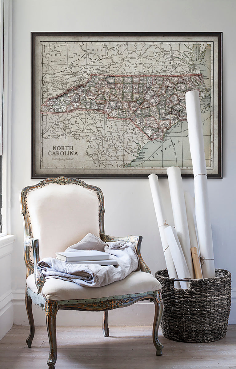 Vintage historic map of North Carolina in room with white walls with vintage furniture and vintage decor.