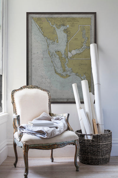 Vintage historic nautical chart of Lemon Bay, Florida in room with white walls with vintage furniture and vintage decor.