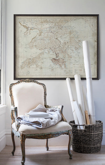 Vintage historic Hong Kong map in room with white walls with vintage furniture and vintage decor.