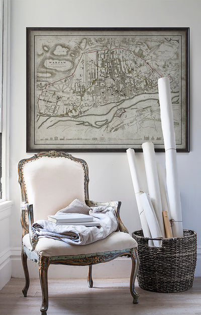 Vintage historic map of Warsaw, Poland in room with white walls with vintage furniture and vintage decor.
