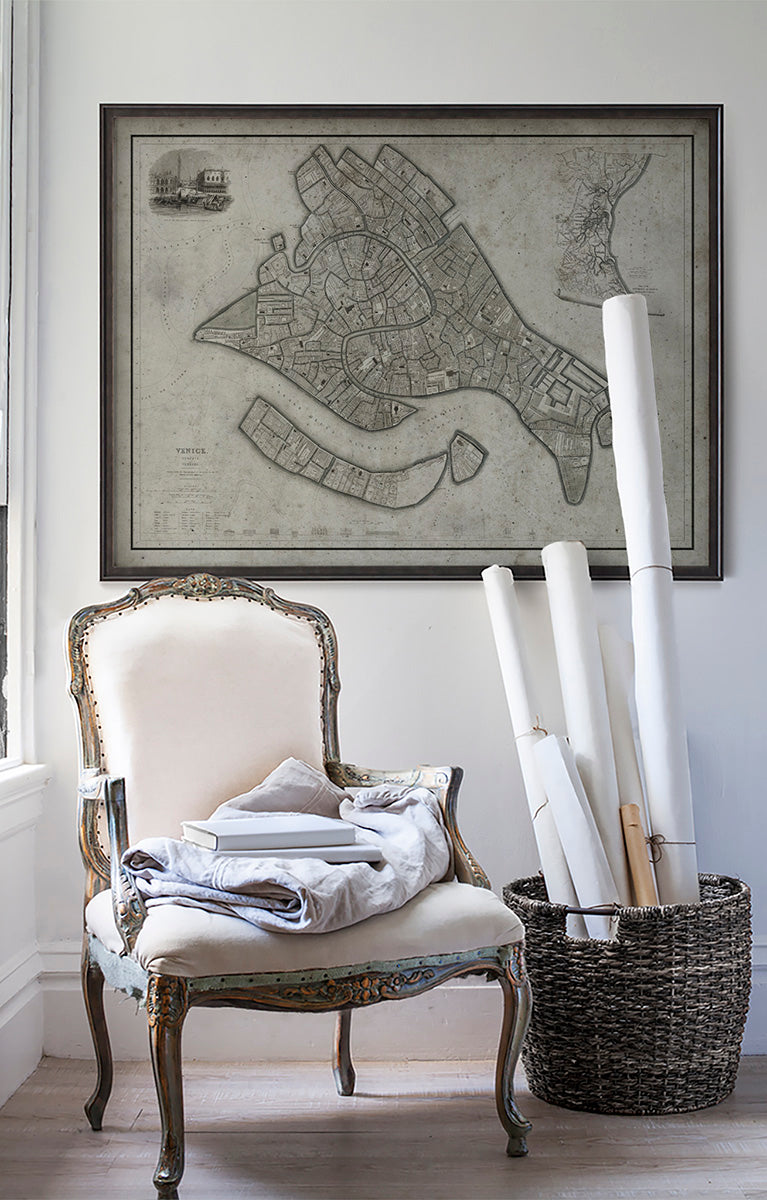 Vintage historic map of Venice in room with white walls with vintage furniture and vintage decor.