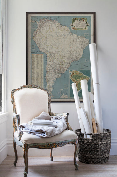 Vintage historic map of South America in room with white walls with vintage furniture and vintage decor.