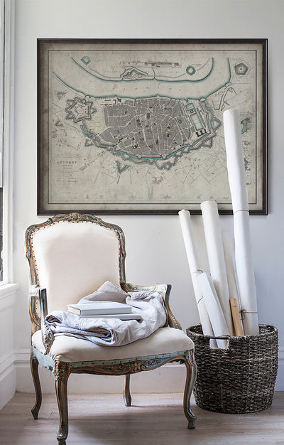 Vintage historic map of Antwerpon white wall with vintage furniture and vintage decor.