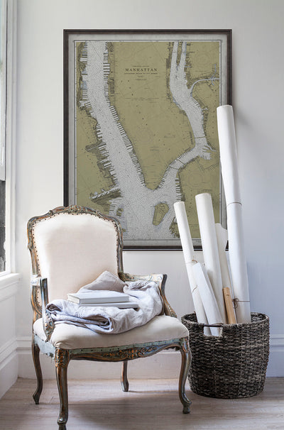 Vintage historic nautical chart of Manhattan, New York in room with white walls with vintage furniture and vintage decor.