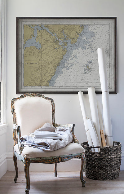 Vintage historic nautical chart of Portsmouth, New Hampshire in room with white walls with vintage furniture and vintage decor.