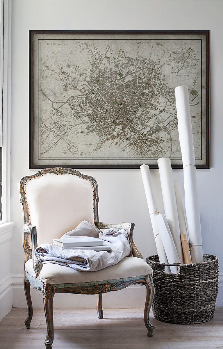 Vintage historic map of Birmingham, England in room with white walls with vintage furniture and vintage decor.