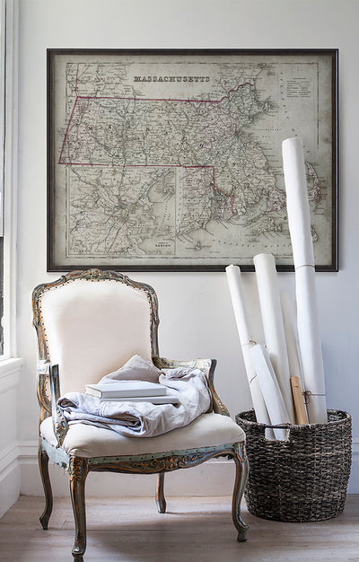 Vintage historic road map of Massachusetts in room with white walls with vintage furniture and vintage decor.