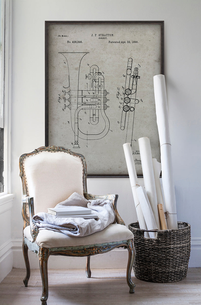Vintage cornet horn patent poster print art in room with white walls with vintage furniture and vintage decor.