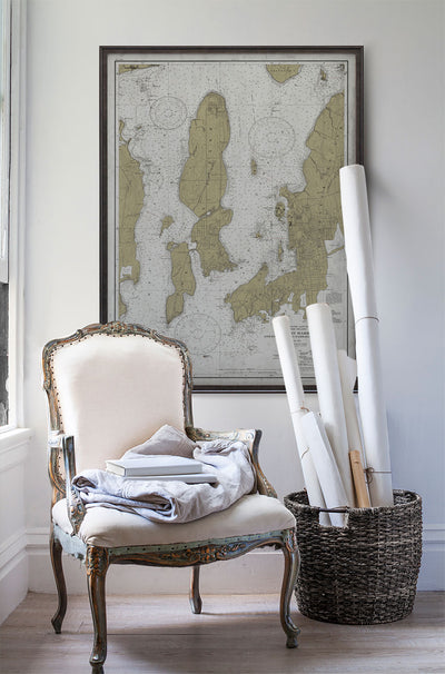 Vintage historic nautical chart of Newport, Rhode Island in room with white walls with vintage furniture and vintage decor.